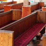 Empty church pews representing Americans leaving their childhood religion and shifting religious identity, according to Pew Research Center findings.
