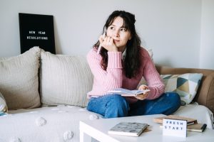 Woman journaling during the New Year, reflecting on becoming through daily habits, personal growth, and intentional spiritual discipline.