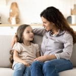 Mother and daughter talking peacefully on the couch, illustrating calm parenting, emotional mastery, and the power of a soft answer in the home.