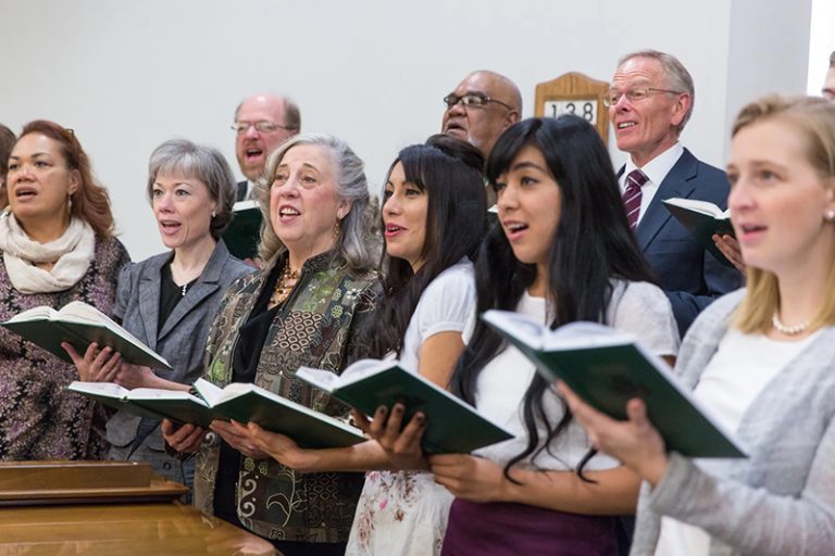 Latter-day Saint congregation singing hymns together, showing how sacred Christmas music invites the Spirit and brings peace.