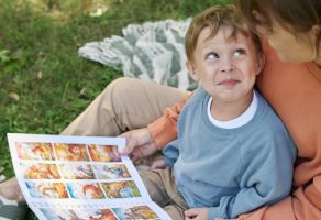 Parent and child reading a picture book together outdoors, representing the best picture books of 2025 and the shared joy of illustrated children’s books.