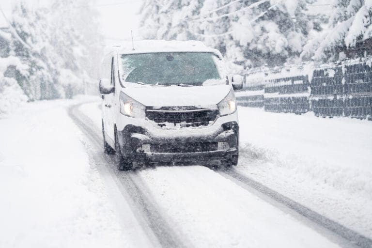 vehicle driving through snowstorm showing emergency preparedness and disaster readiness