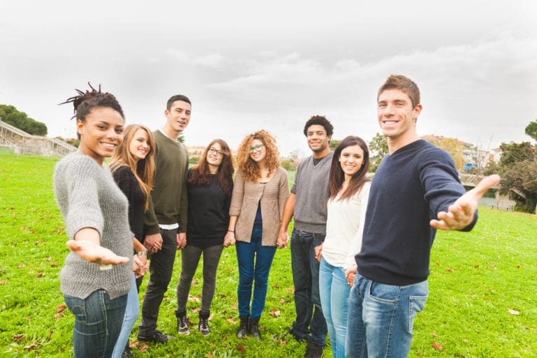 A diverse group of people standing together outdoors, illustrating the Golden Rule, compassion, and treating others with kindness as a New Year principle.