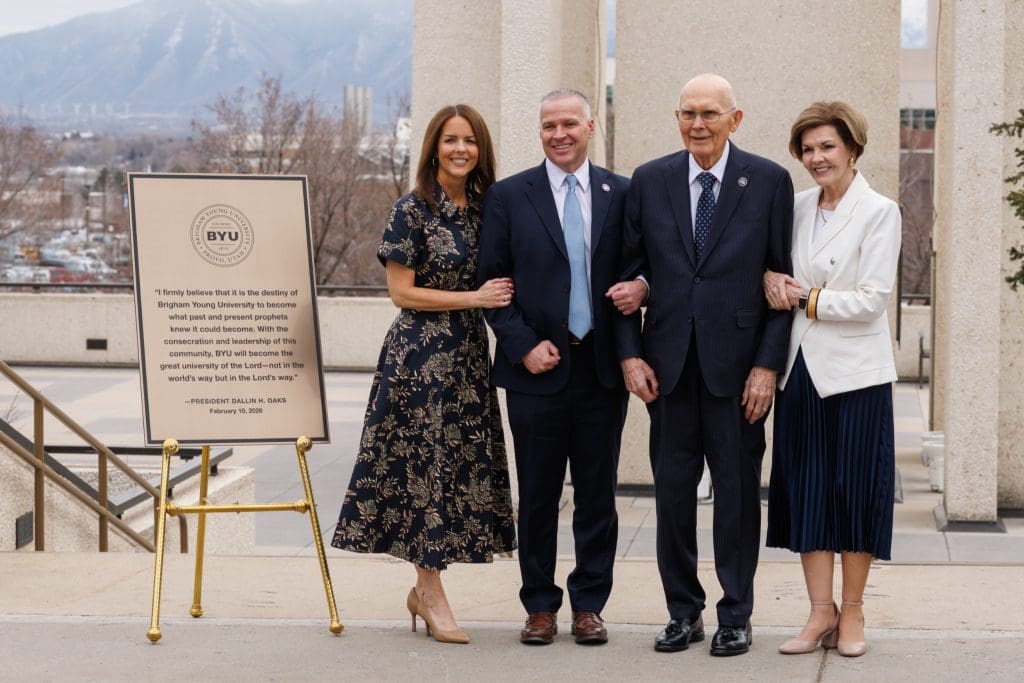 President Dallin H. Oaks stands with BYU President C. Shane Reese and their wives beside a newly unveiled plaque featuring a quote from Oaks’ February 10, 2026 devotional address at Brigham Young University near the Carillon Bell Tower.