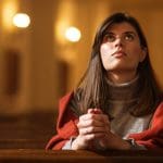 Latter-day Saint woman praying in a church, reflecting the real faith and daily life of Latter-day Saint women often misrepresented by television shows