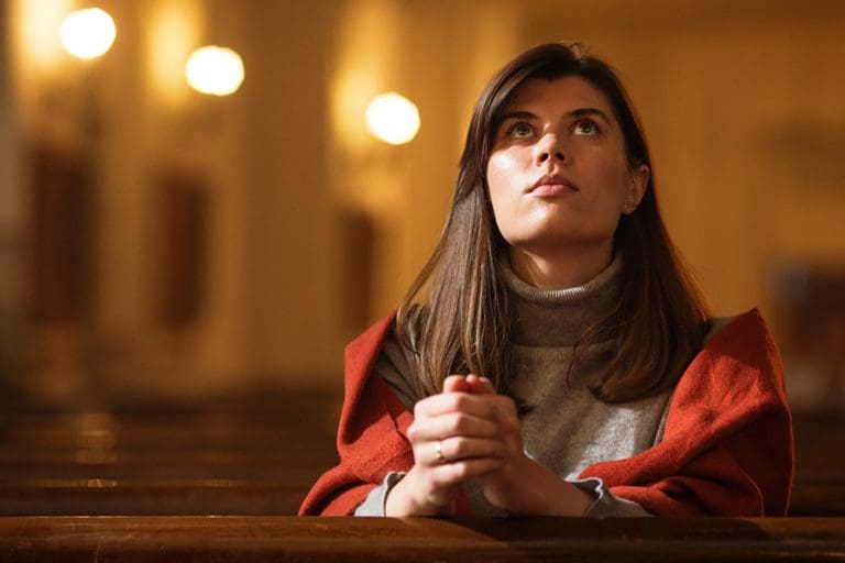 Latter-day Saint woman praying in a church, reflecting the real faith and daily life of Latter-day Saint women often misrepresented by television shows