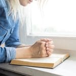 Woman praying over scripture representing seeking Correction, divine chastening, and humility in receiving criticism.