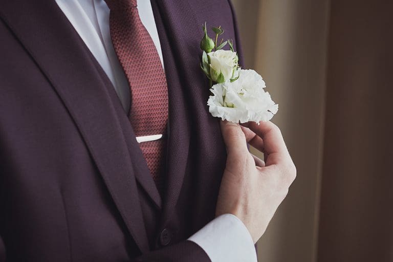 Groom adjusting boutonniere symbolizing Christ the Bridegroom and eternal covenant through baptism and priesthood authority.