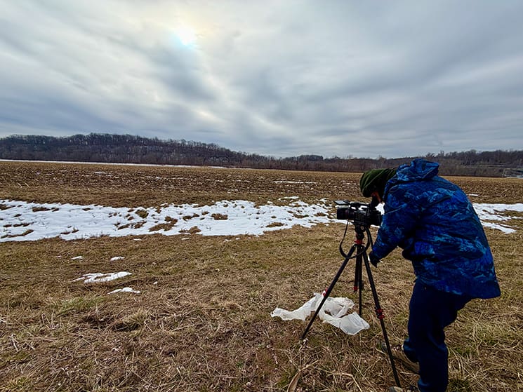 A filmmaker sets up a camera on frozen ground during a winter shoot for the Joseph Smith documentaries, recreating landscapes central to Joseph Smith’s life and ministry.
