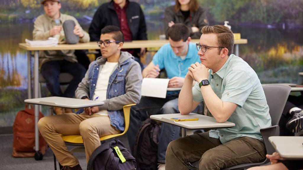 Students sit attentively in an Institute classroom, demonstrating engagement in gospel learning within the Seminary and Institute program.