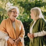 Two women using strong communication skills with positive body language and tone of voice in conversation.