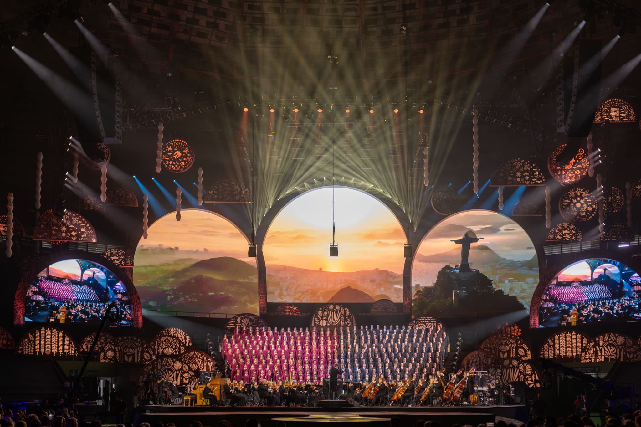 The Tabernacle Choir and Orchestra at Temple Square perform before a massive stage display featuring Rio de Janeiro imagery during the “Songs of Hope” tour in São Paulo.