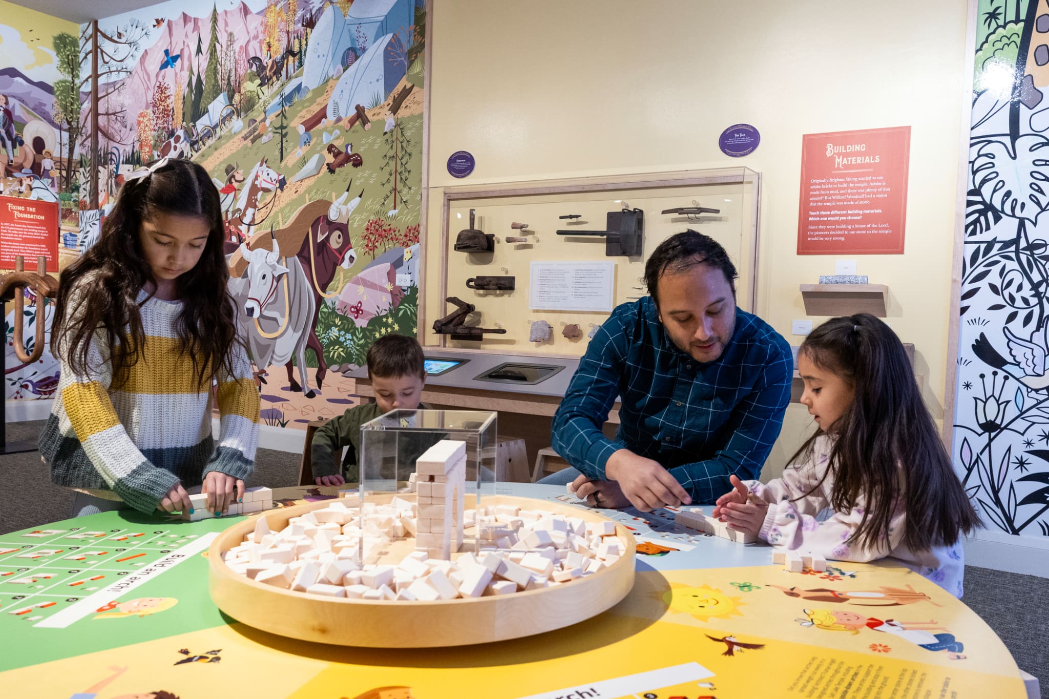 Families and children participate in the “A Firm Foundation” exhibit at the Church History Museum, building structures that symbolize strong spiritual foundations.
