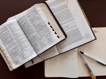 Open scriptures with a journal and pen, representing personal study and reflection during Lent and Holy Week as believers prepare spiritually for Easter and the Resurrection of Jesus Christ.