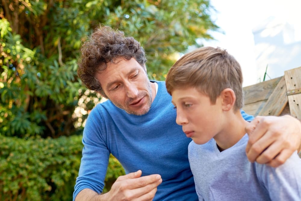 father guiding son outdoors showing effective parenting principles and compassionate parenting
