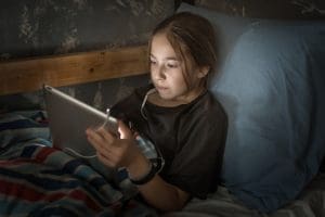 child using device alone representing outsourcing of parenting and reduced parental involvement in child development