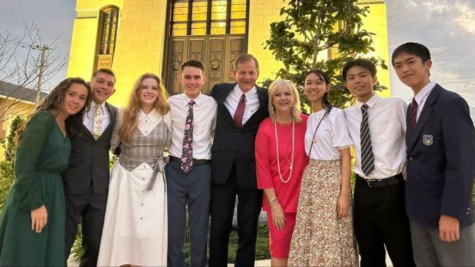Latter-day Saint family gathered outside a temple, symbolizing faith, unity, and temple-centered worship in the global Church.