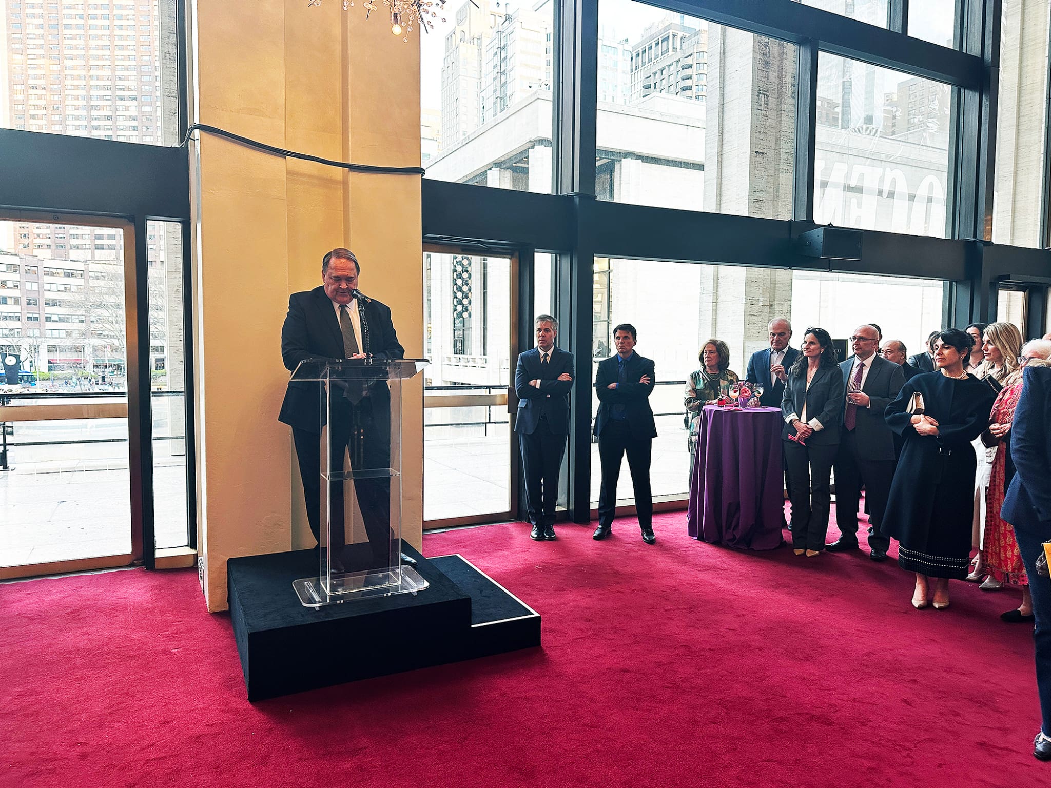 A speaker addresses guests at a formal reception before the Lamb of God oratorio performance at the Metropolitan Opera House, reflecting on Jesus Christ and Holy Week.