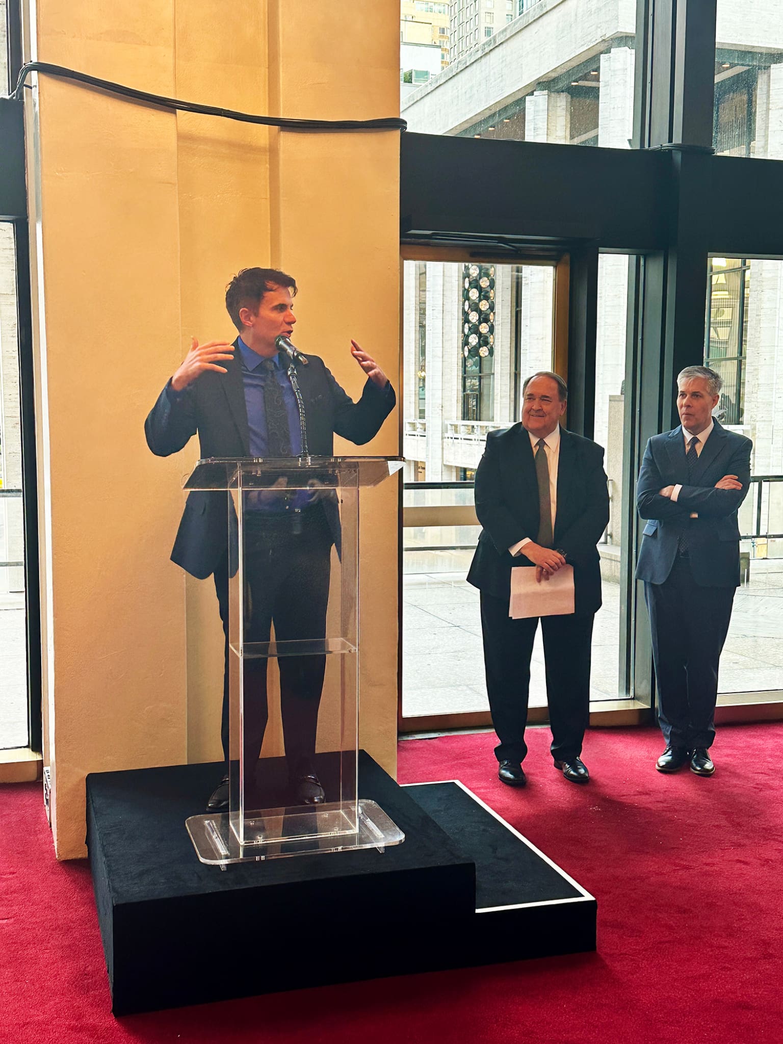 A presenter speaks passionately at a pre-performance event for Lamb of God by Rob Gardner, emphasizing the sacred message of the oratorio.
