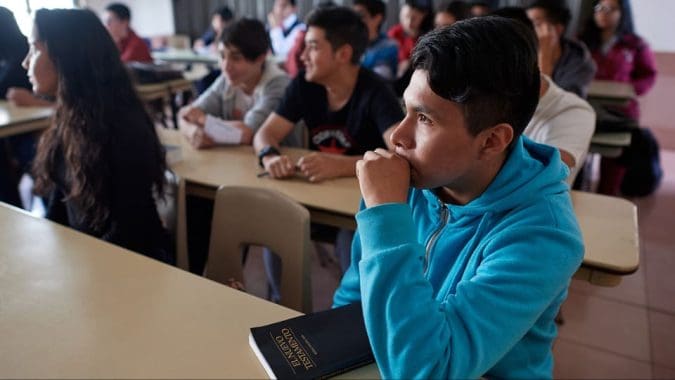Students seated in a seminary class studying scriptures, representing growing enrollment in Church education programs worldwide.