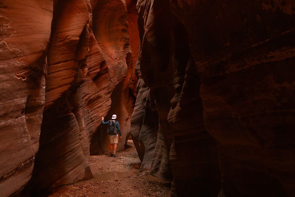 Backpacker hiking through Buckskin Gulch in Paria Canyon during the Ocean to Ice wilderness adventure
