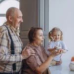 Grandparents and granddaughter sharing a joyful family moment that reflects bonding, emotional empathy, and loving grandparent relationships.