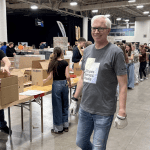 Volunteers packing food boxes at Silicon Slopes Serves Meals to support Utah families in need and fight food insecurity.